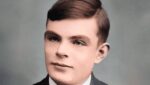 Foto de rosto de Alan Turing, criador do teste de Turing, vestindo camisa branca e terno preto. A foto ilustra o artigo "Teste de Turing: Desvendando o critério definidor da AI" escrito pelo psicanalista Homero Mônaco para o site Online Psicanalista.