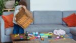 Foto de um menino pegando brinquedo em uma caixa de vime e colocando no chão para brincar. A foto ilustra o artigo "Terapia da Brincadeira" escrito pelo psicanalista Homero Monaco para o site online psicanalista.