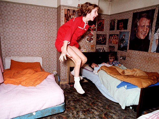 Foto promocional do documentário da Apple TV, onde Janet Hodgson está sendo jogada a noite para fora da cama. A foto ilustra o artigo O Poltergeist de Enfield e seus mistérios: Uma Análise Psicanalítica escrito pelo psicanalista Homero Mônaco para o site Online Psicanalista.