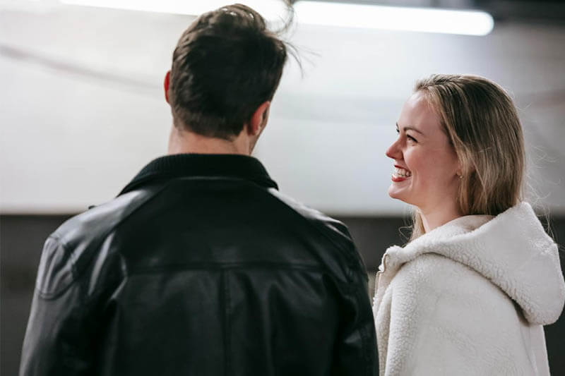 Foto de um casal de namorados sentados, uma está olhando para o outro e a mulher está confiante e sorridente. A foto ilustra o artigo 5 Melhores Maneiras de Aumentar a sua Confiança nos Relacionamentos escrito pelo psicanalista Homero Monaco para o site Online Psicanalista.