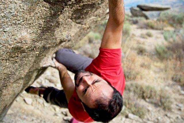 Foto de um homem escalando uma pedra apenas coma força das mãos. A foto ilustra o artigo 10 Maneiras de Alcançar o Empoderamento Pessoal Com a Psicanálise escrito pelo psicanalista Homero Mônaco para o site Online Psicanalista.