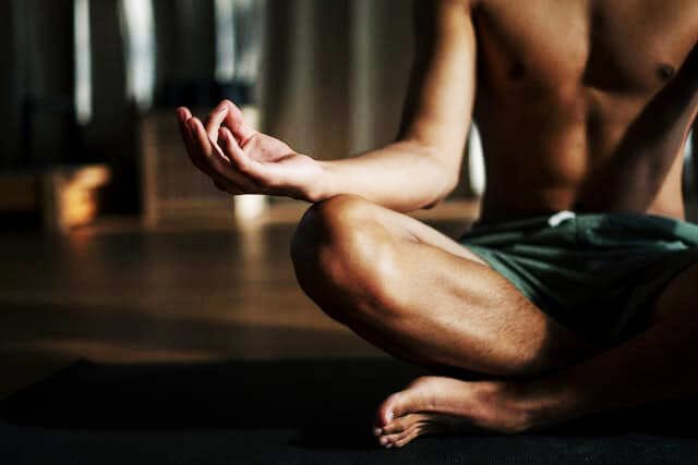 Foto de um homem meditando em sua sala para manter o seu bem-estar emocional. A foto ilustra o artigo 10 Melhores Práticas para Promover o Bem-Estar Emocional escrito pelo psicanalista Homero Mônaco para o site Online Psicanalista.