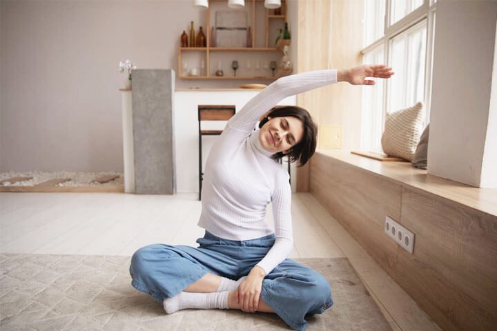 Foto de uma mulher de cabelos castanhos sentada no chão estirando-se com cara de positivismo. A foto ilustra o artigo Por que desconstruir os seus padrões comportamentais por meio da sua aceitação e da sua transformação escrito pelo psicanalista Homero Mônaco para o site Online Psicanalista.Foto de uma menina com perna levantada como se fosse pisar na lente da câmera que a fotografa. A foto ilustra o artigo 7 Maneiras como a terapia ajuda a superar hábitos autossabotadores escrito pelo psicanalista Homero Mônaco para o site Online Psicanalista.