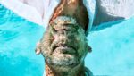 Foto do rosto de um homem enfiando a cabeça em uma piscina, e com a mesma refletindo na água, fazendo referência ao inconsciente. A foto ilustra o artigo Aproveitando o Poder da Mente Inconsciente escrito pelo psicanalista Homero Mônaco para o site Online Psicanalista.