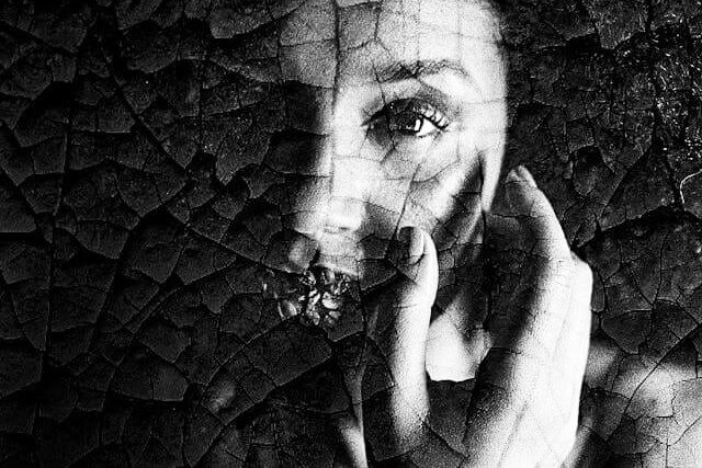 Foto do rosto de uma mulher de frente. O rosto da mulher parece todo craquelado e desconfigurado. A foto ilustra o artigo O que são Transtornos de Personalidade? Quais são os tipos? Quais são os sintomas? Como tratá-los? escrito pelo psicanalista Homero Mônaco para o site Online Psicanalista.