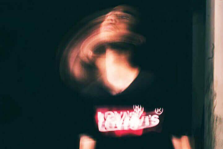 Foto de um jovem sentado no chão, onde a foto mostra movimento e um efeito de sombra de movimento da sua imagem como se tivesse sofrendo uma alucianação. A foto ilustra o artigo O que são transtornos psicológicos? Quais são eles? Como tratá-los? escrito no blog do psicanalista Homero Mônaco para ao site Online Psicanalista.